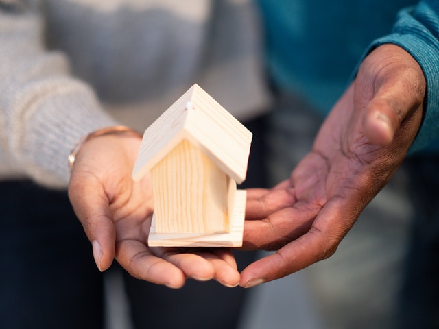 Photo of hands holding a little model home